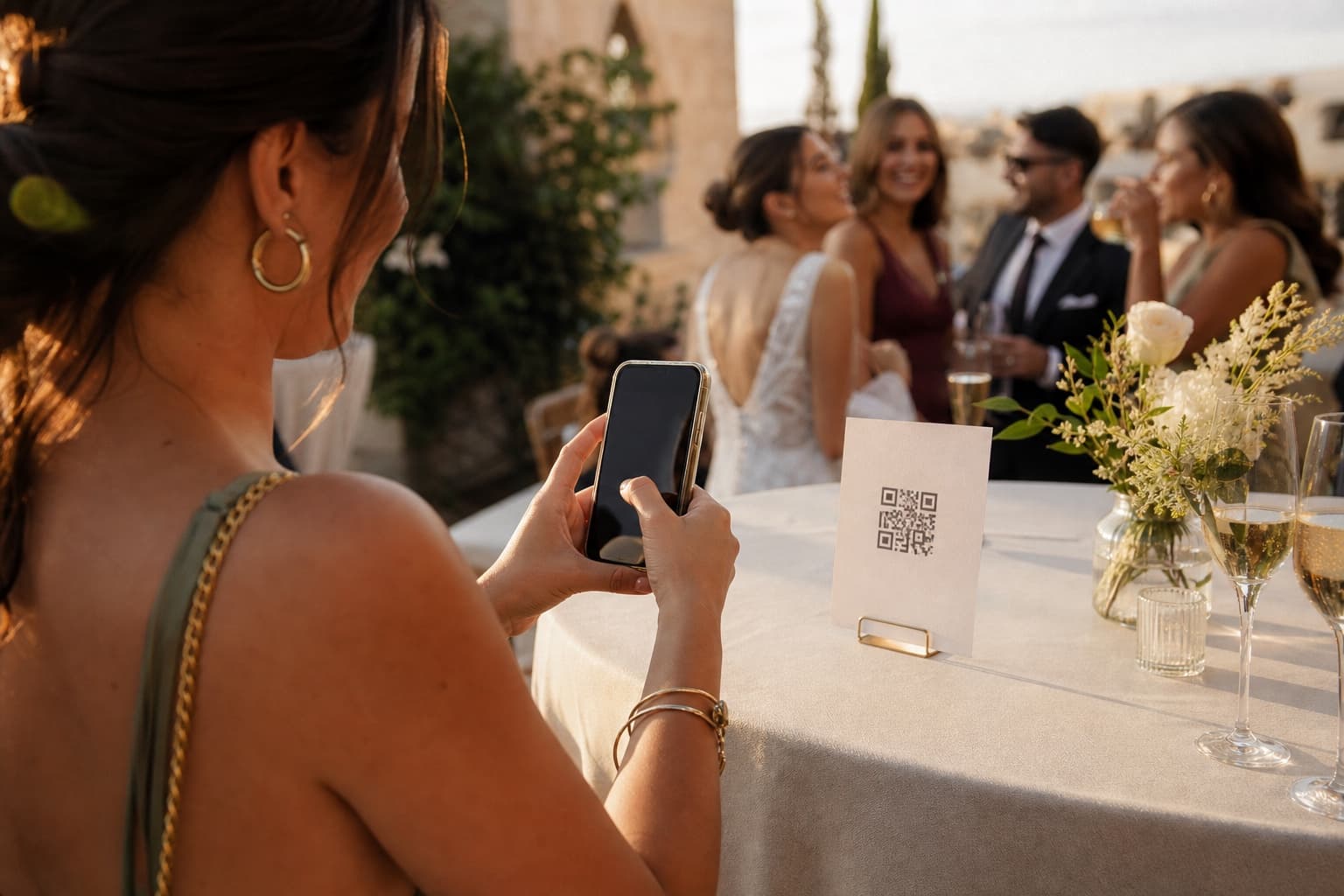 Invitada escaneando un código QR para compartir fotos durante el cóctel de una boda
