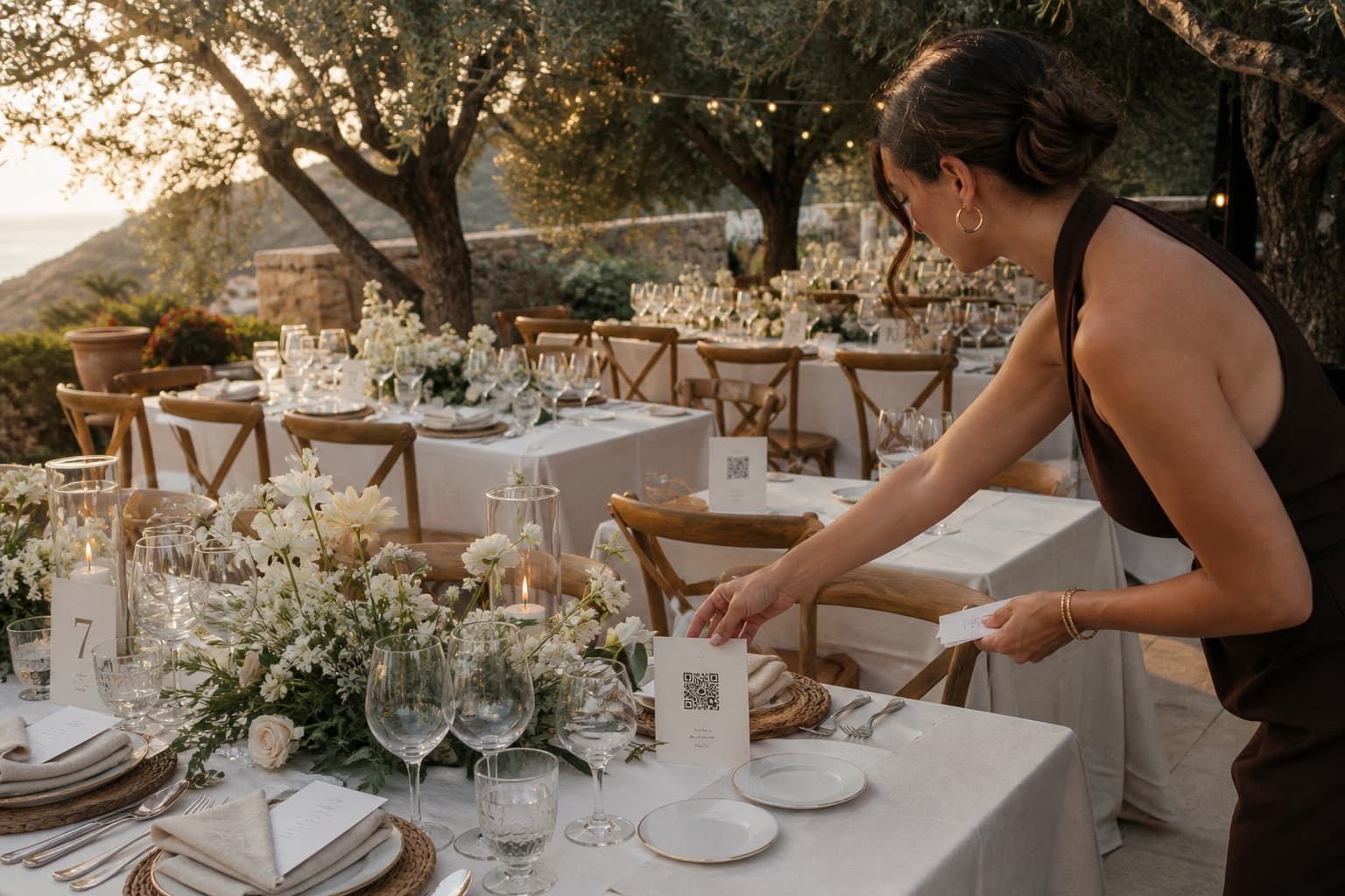 Organizadora colocando tarjetas con código QR en las mesas de una boda mediterránea