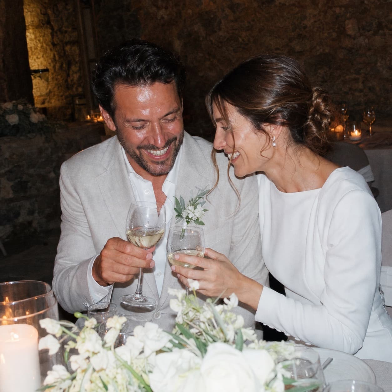 Lucía y Mateo ríen durante un brindis en la mesa